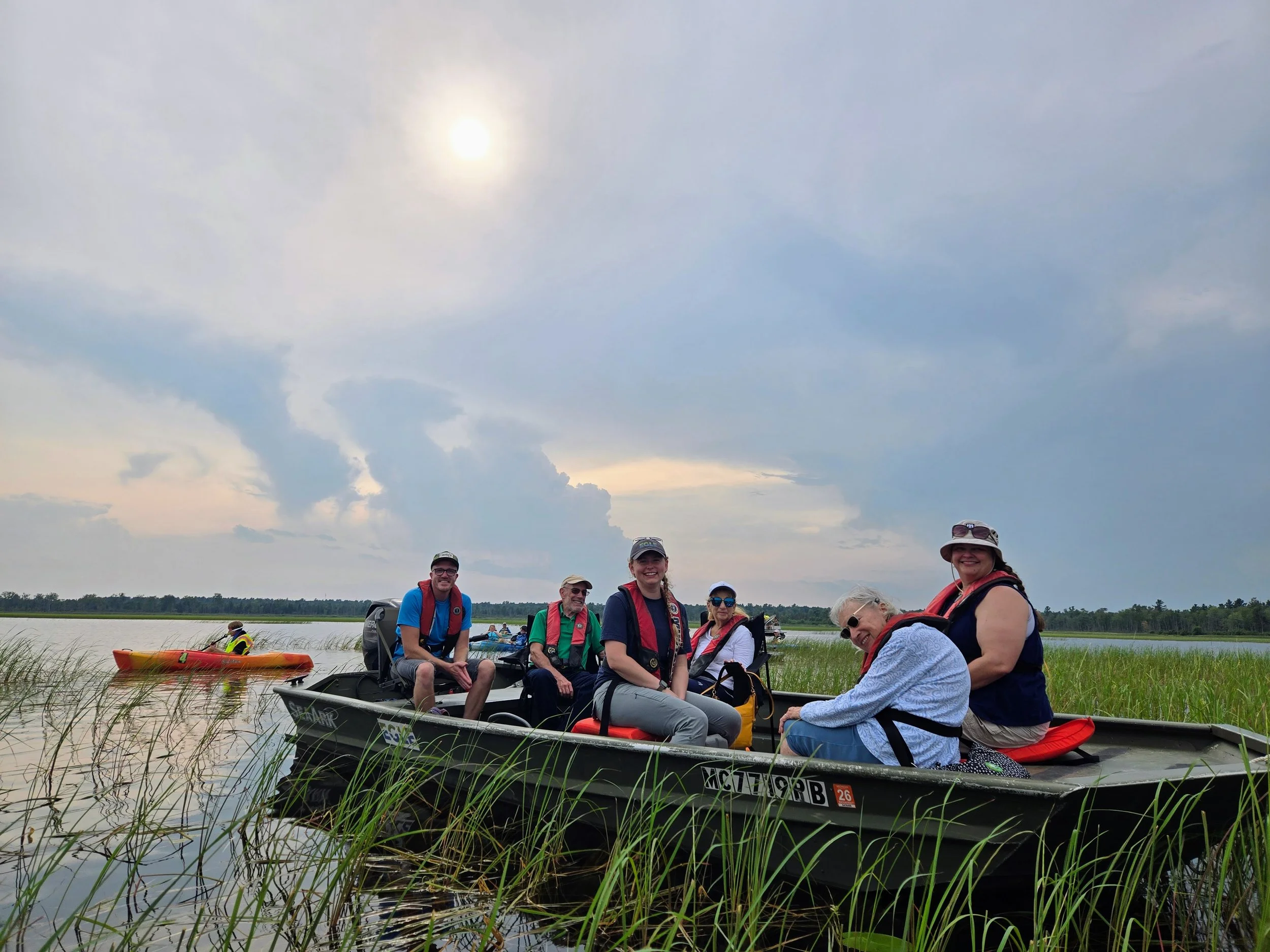 Attendees explore Tawas Lake from the Michigan EGLE jon boat.
