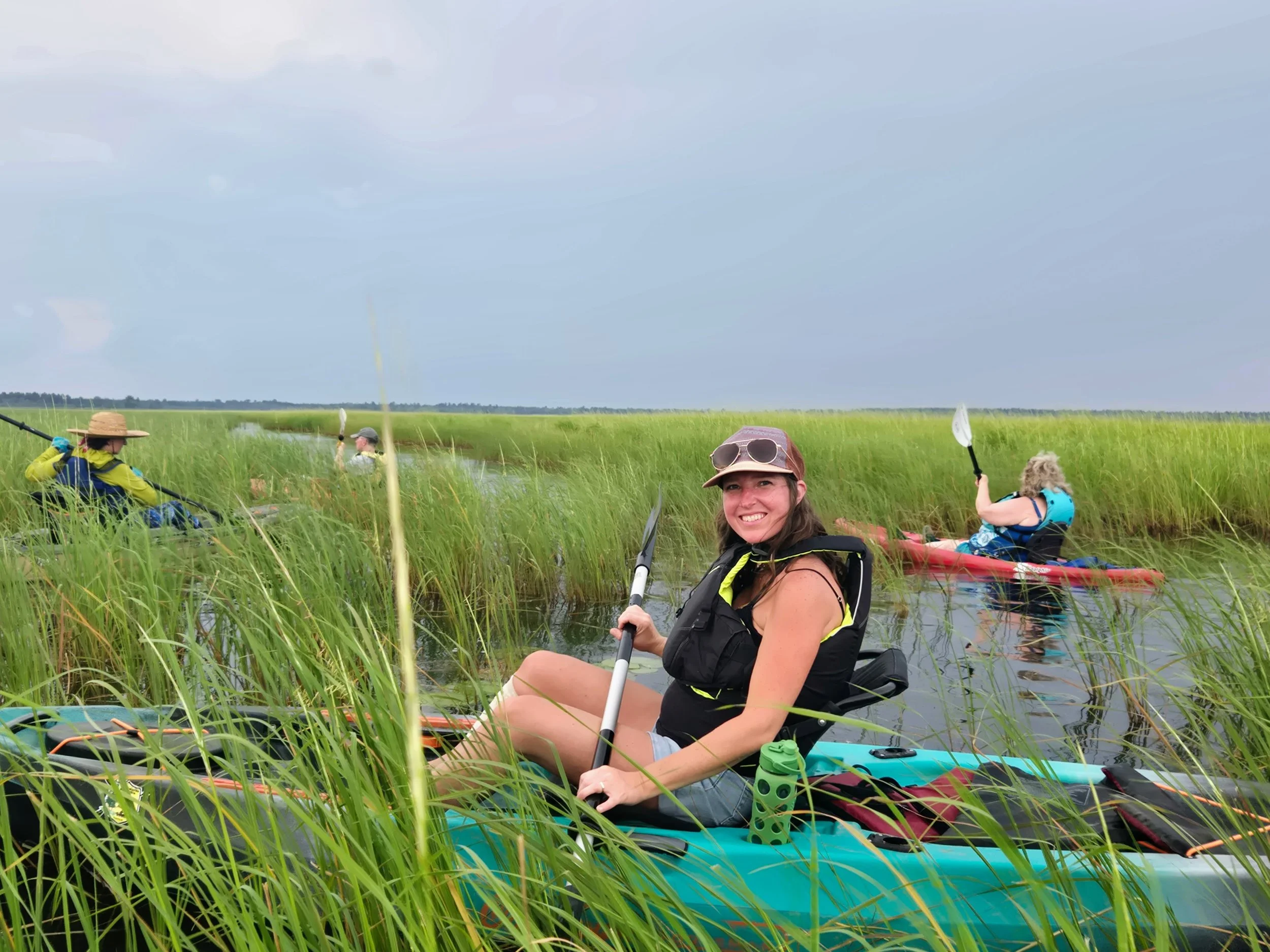 Katharine Chornyak paddles a kayak through the wild rice.