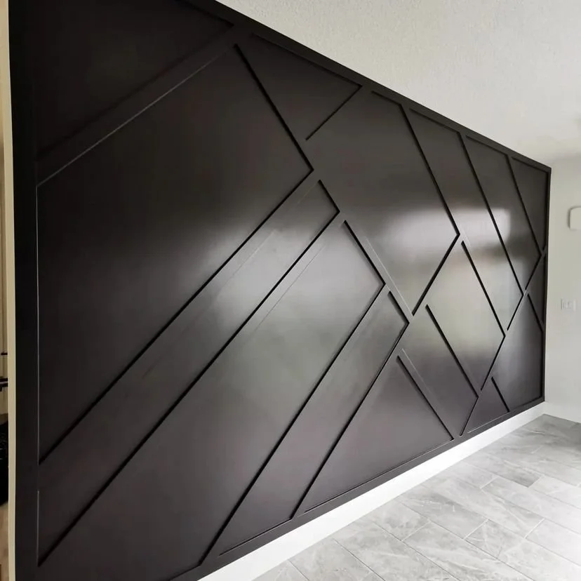 Black geometric wall accent with diagonal and rectangular panels in a modern interior space.