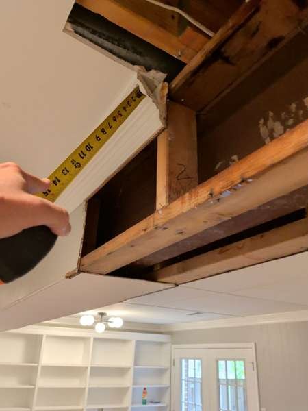 Measuring water-damaged ceiling framing to assess repair scope