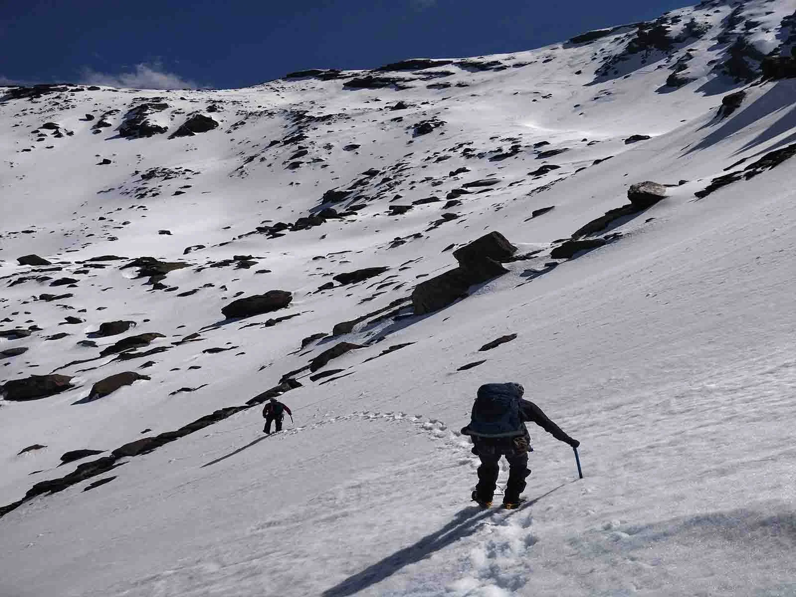 People walking across a snow slope as part of a winter mountaineering course