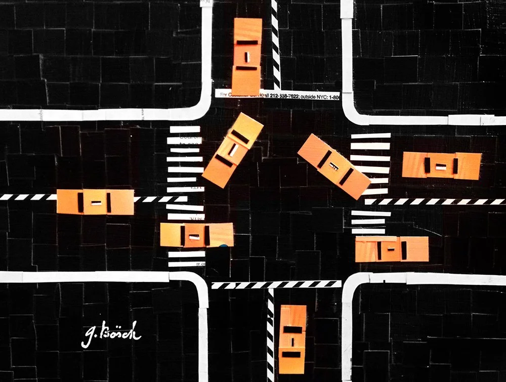 Miniature orange cars on a black and white road layout model with intersections, crosswalks, and curving roads.