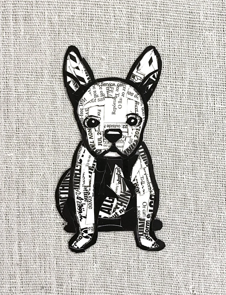 Artwork of a dog made from cut-out pieces of black and white printed paper arranged to form the dog's shape, sitting on a textured surface.