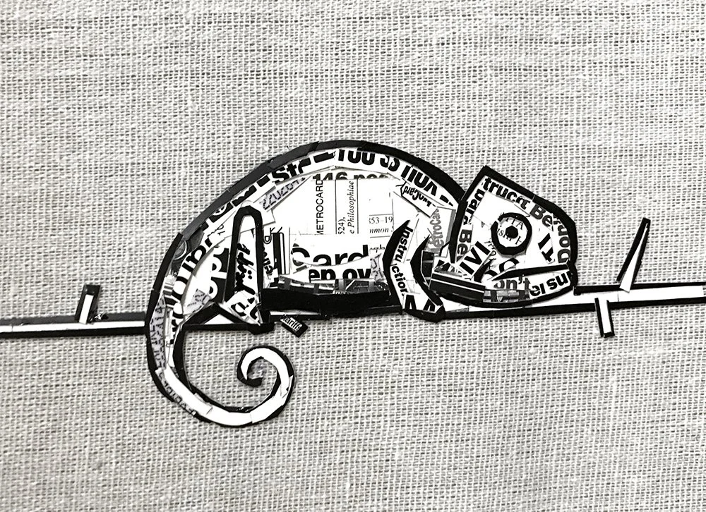 Artistic metal sculpture of a chameleon, crafted from cut-out pieces of printed paper with text, mounted on a horizontal bar against a textured background.