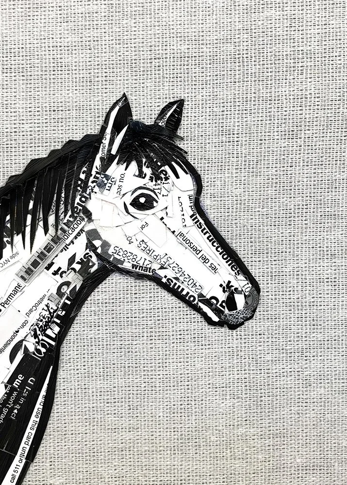 Artistic horse head sculpture made from shredded black and white paper, placed against a gray textured background.