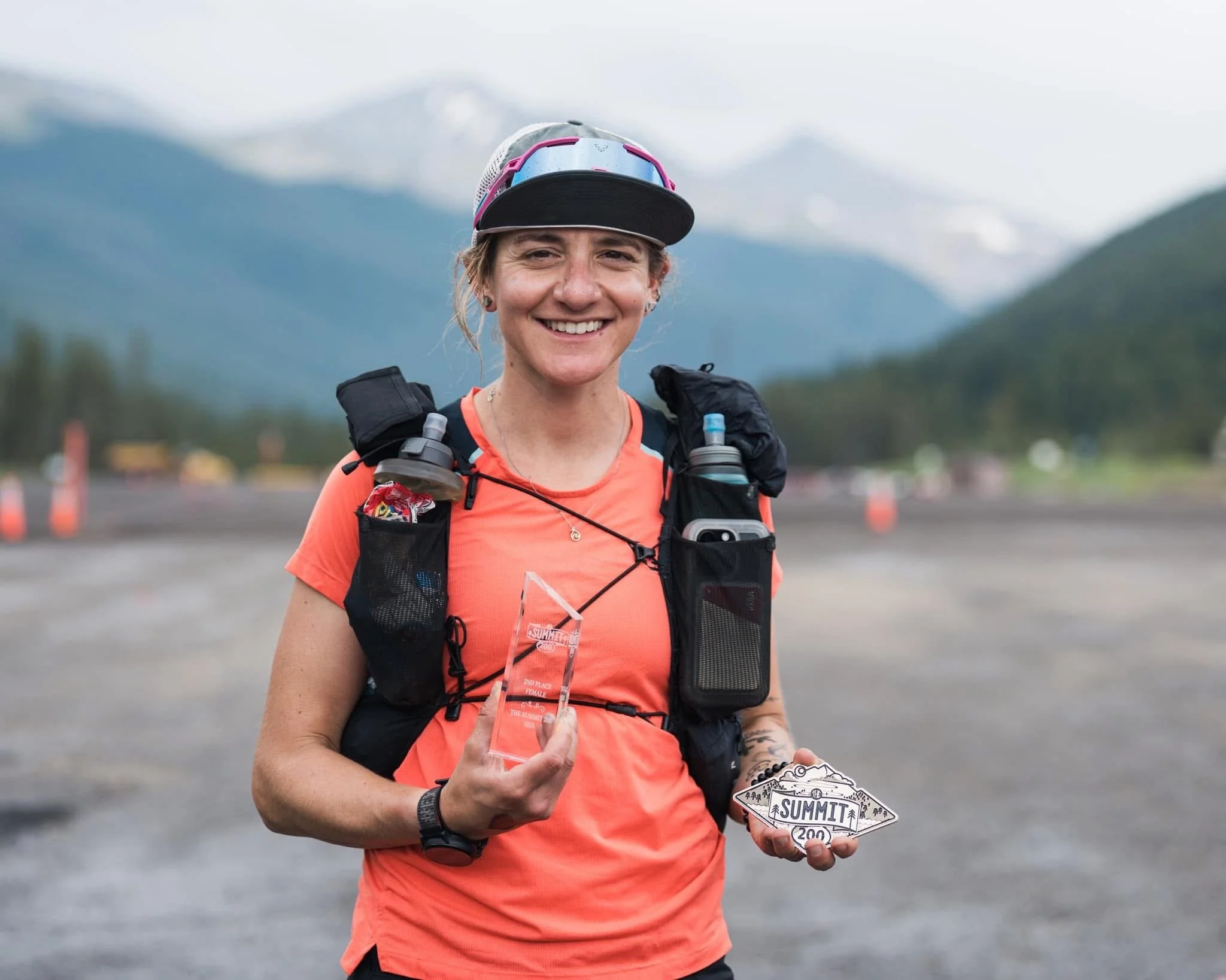Johna in a running vest holding awards