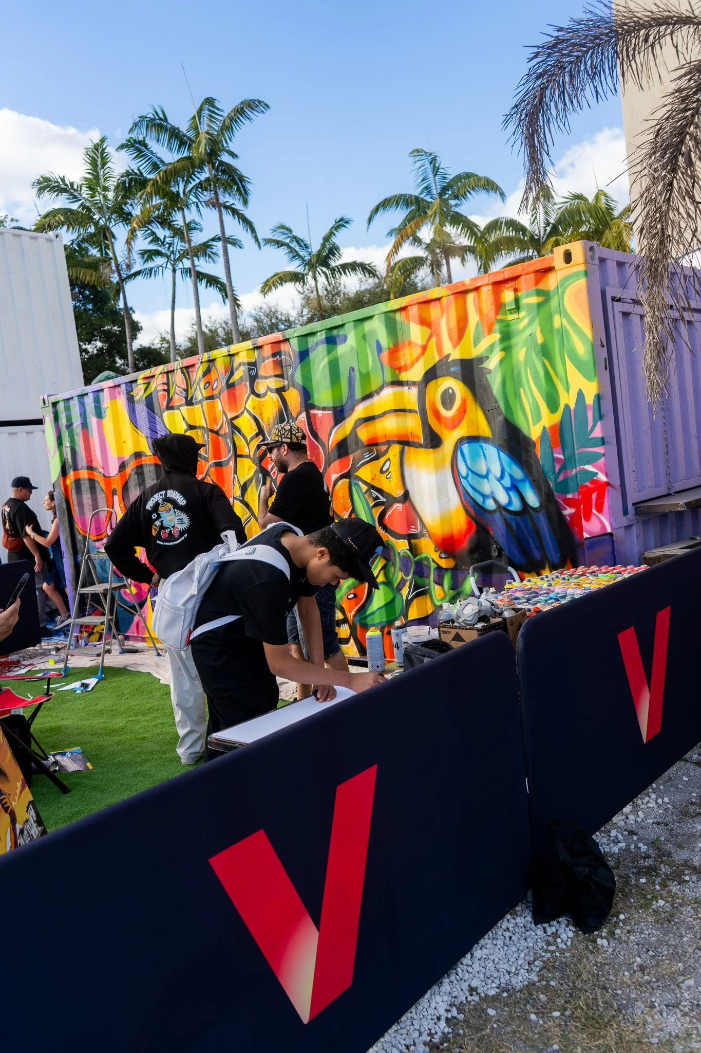 HIVE 2024 A cocktail art and culinary village in Wynwood Miami Art Week Live painting a Mural Container for Verizon Miami Art Week Art Basel Mural with Roc Sol Dee Perez and Miss Lushy with Project Roadmap Murals at The Wynwood Marketplace with DJ Fr