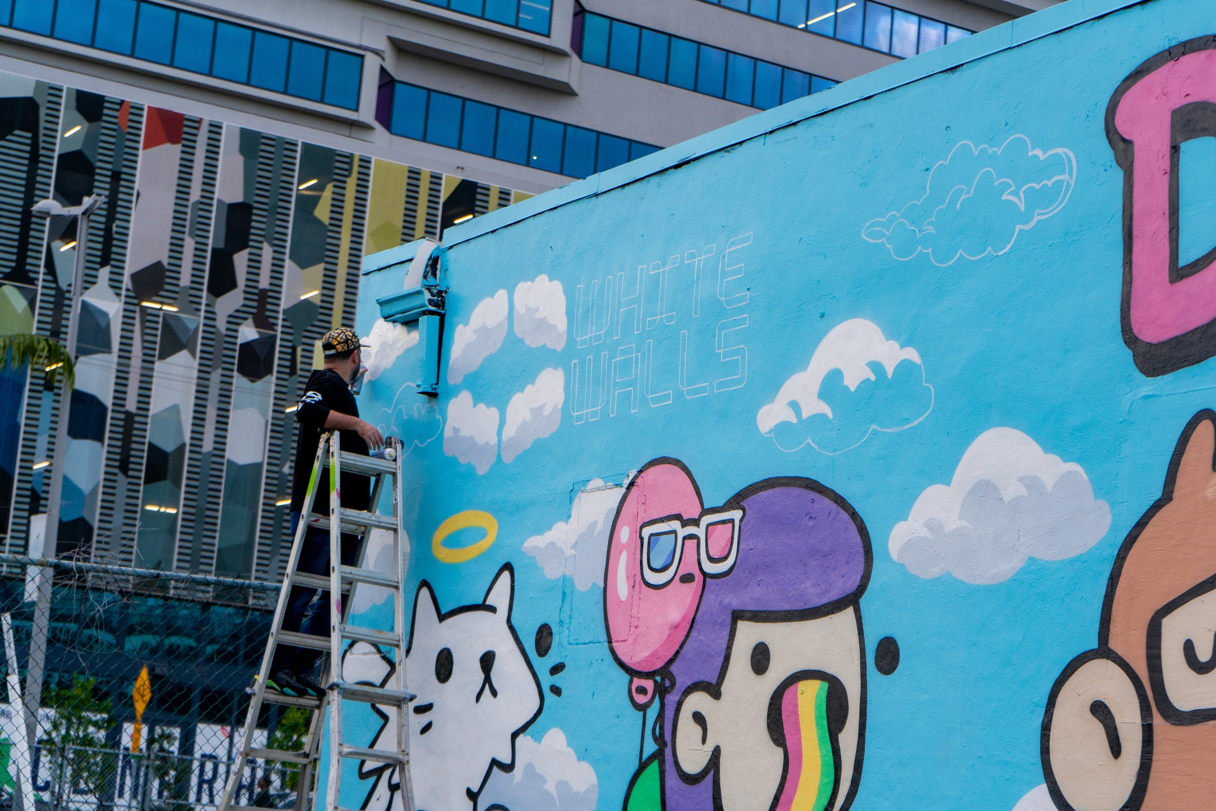 Doodles Mural - White Walls Mural - Miami Wynwood Midtown Miami Murals - Painted by Roc Sol and Dee Perez from Project Roadmap Murals - Wynwood Walls - Wynwood Mural - Miami Murals - Doodles NFT Mural - Pharrell Williams - Street Art - Blondie Whit
