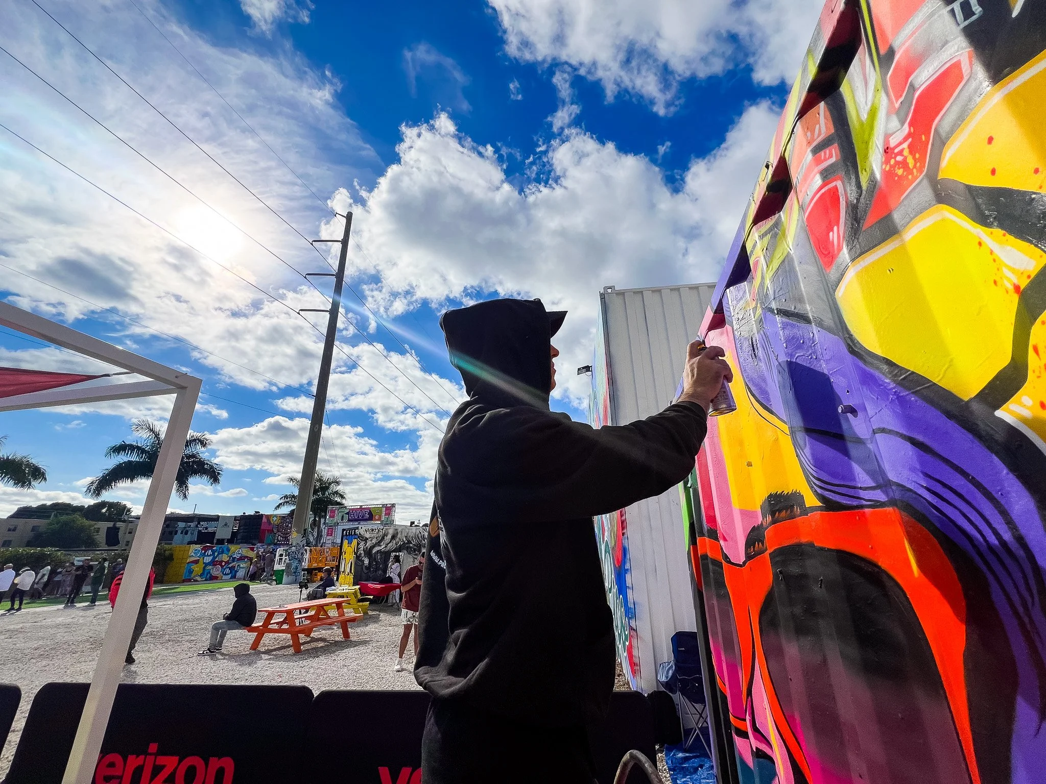 HIVE 2024 A cocktail art and culinary village in Wynwood Miami Art Week Live painting a Mural Container for Verizon Miami Art Week Art Basel Mural with Roc Sol Dee Perez and Miss Lushy with Project Roadmap Murals at The Wynwood Marketplace with DJ Fr