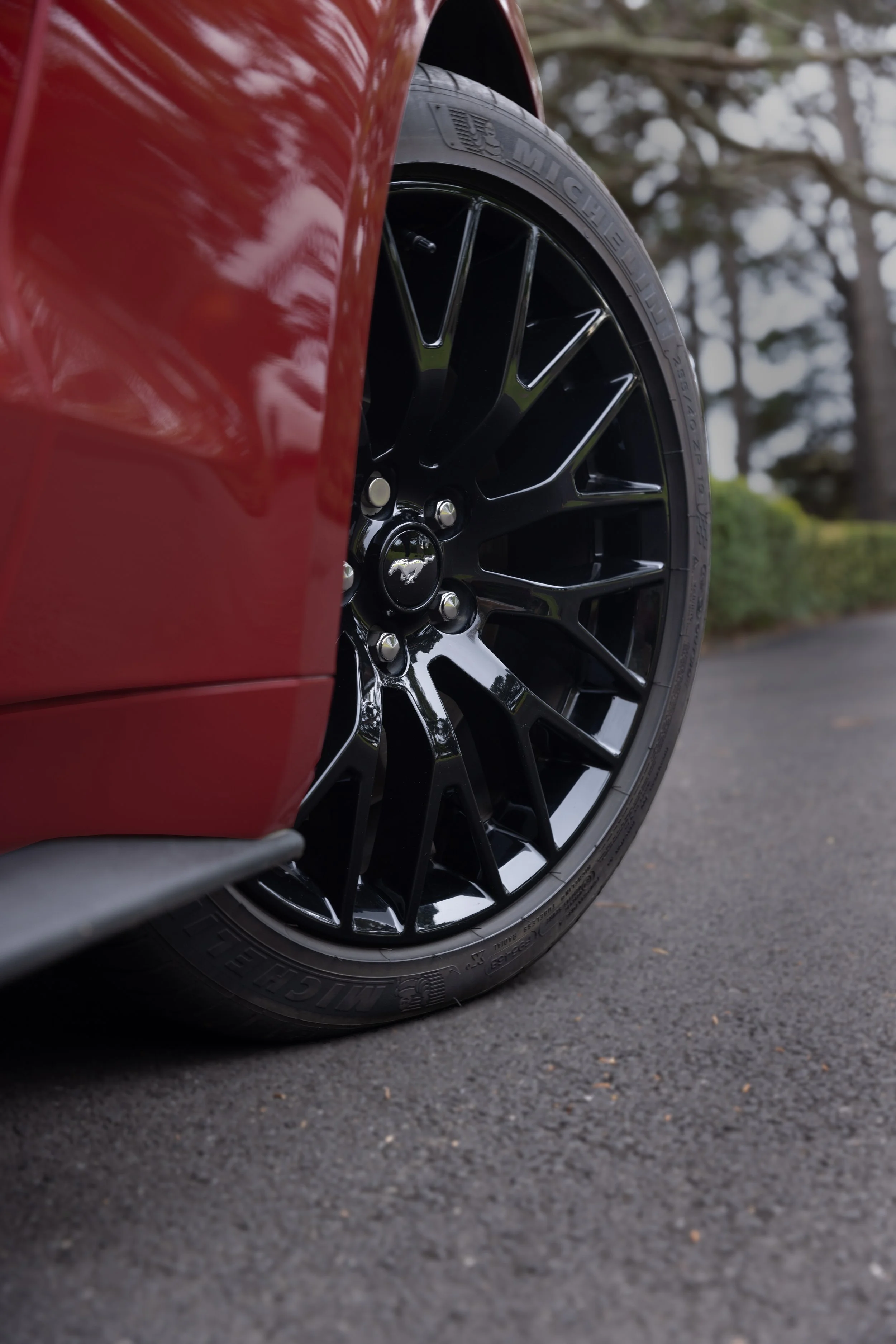 Detail short of wheel of red mustang.