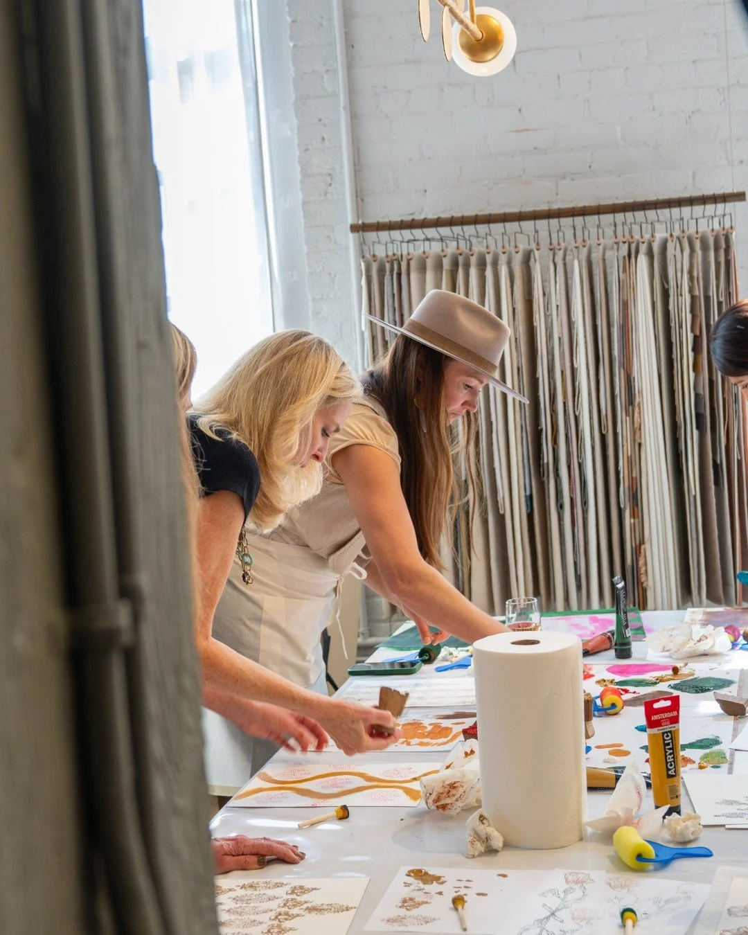 Sunlight hit the table like a spotlight. Paper spread out like evidence. Hands moved with intent. No one asked permission to experiment.

Somebody tests a motif at the edge. Another doubles down on color. Someone pauses mid-motion, recalculates, and 