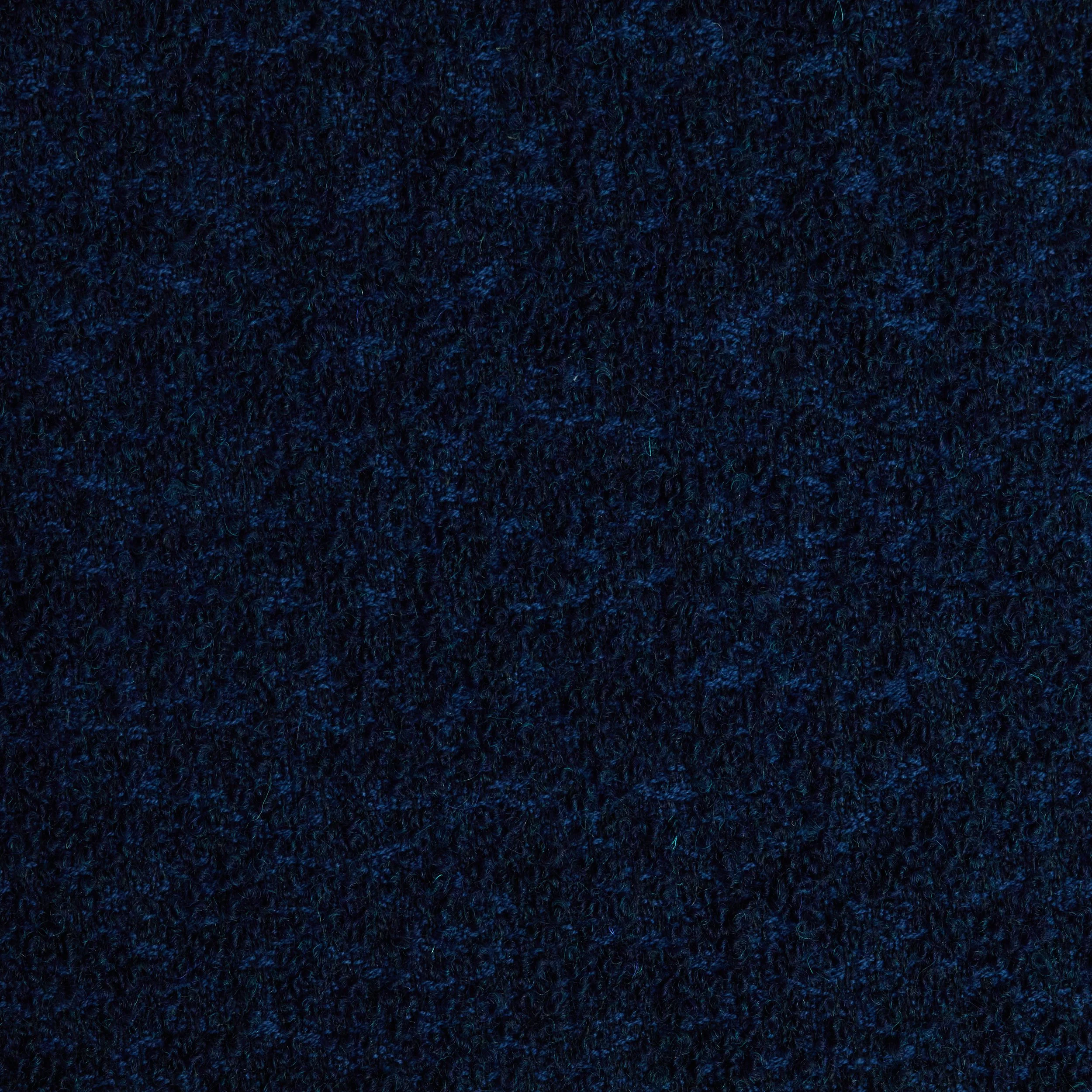 A close-up view of a dark, textured surface, possibly fabric or carpet, with tiny, varied blue specks.