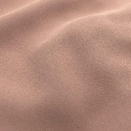 Close-up of a smooth, tan-colored fabric with gentle folds.