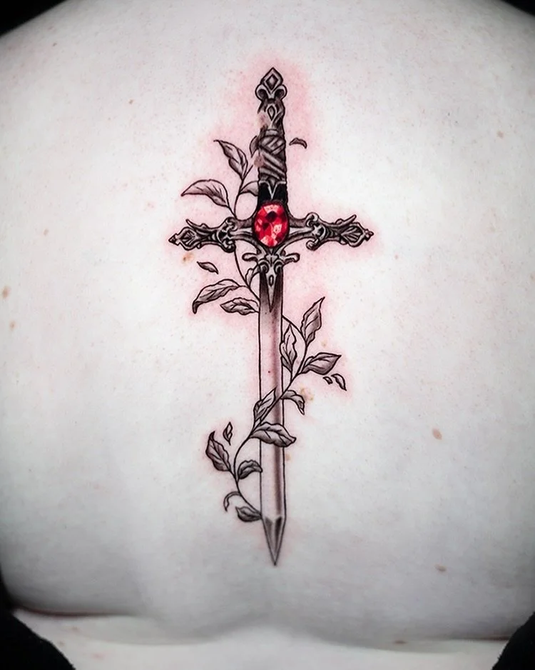 Embracing the elegance of the crimson gem meeting the strength of a sword, entwined by the graceful embrace of nature&rsquo;s leaves. Done on @xjoeyx731 spine. Such a trooper! 

Done at @aztekink 

#eternalink #allegoryink 
#apprenticetattoo #apprent