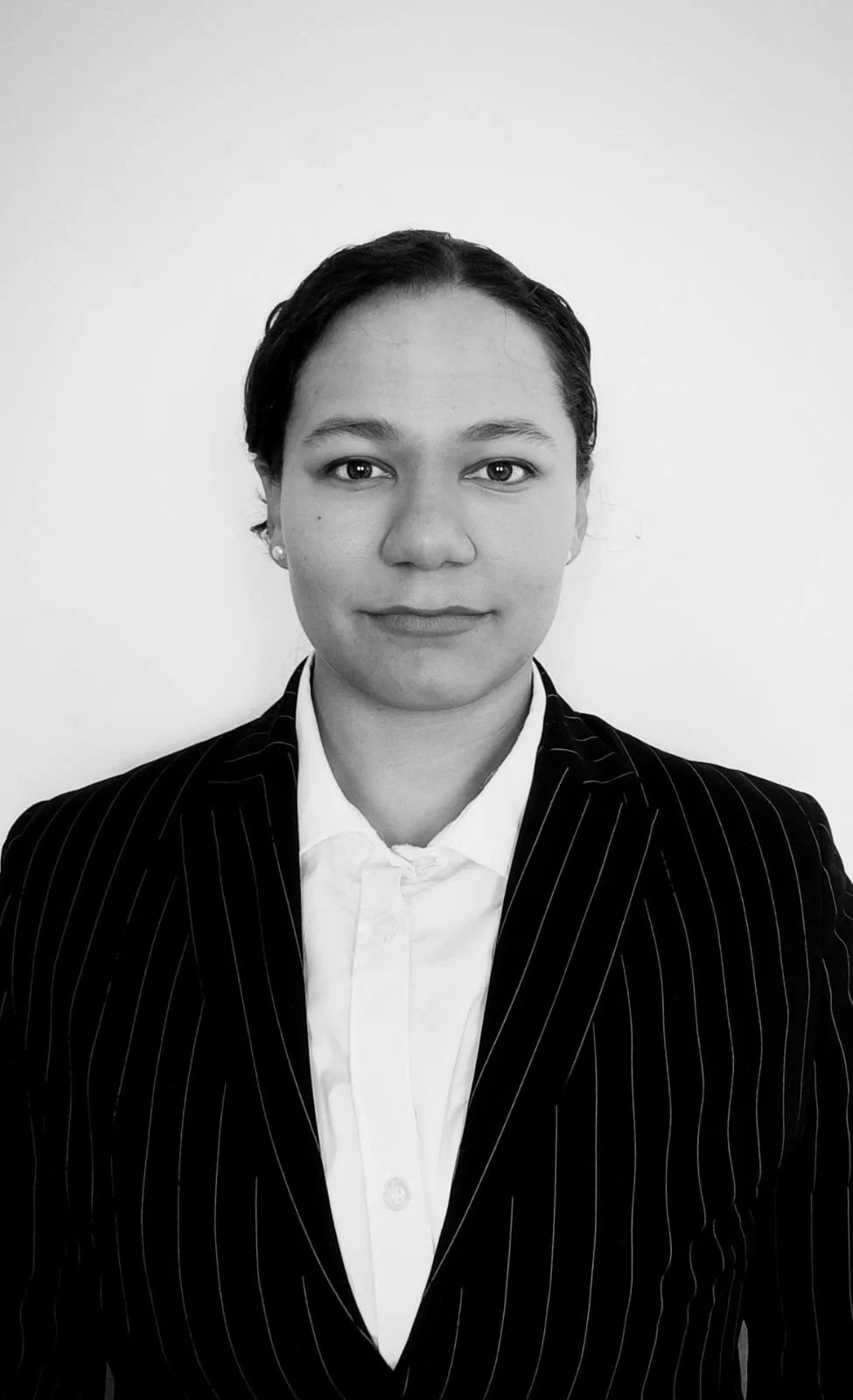 Black and white portrait of a woman in a business suit, facing forward with a neutral expression.