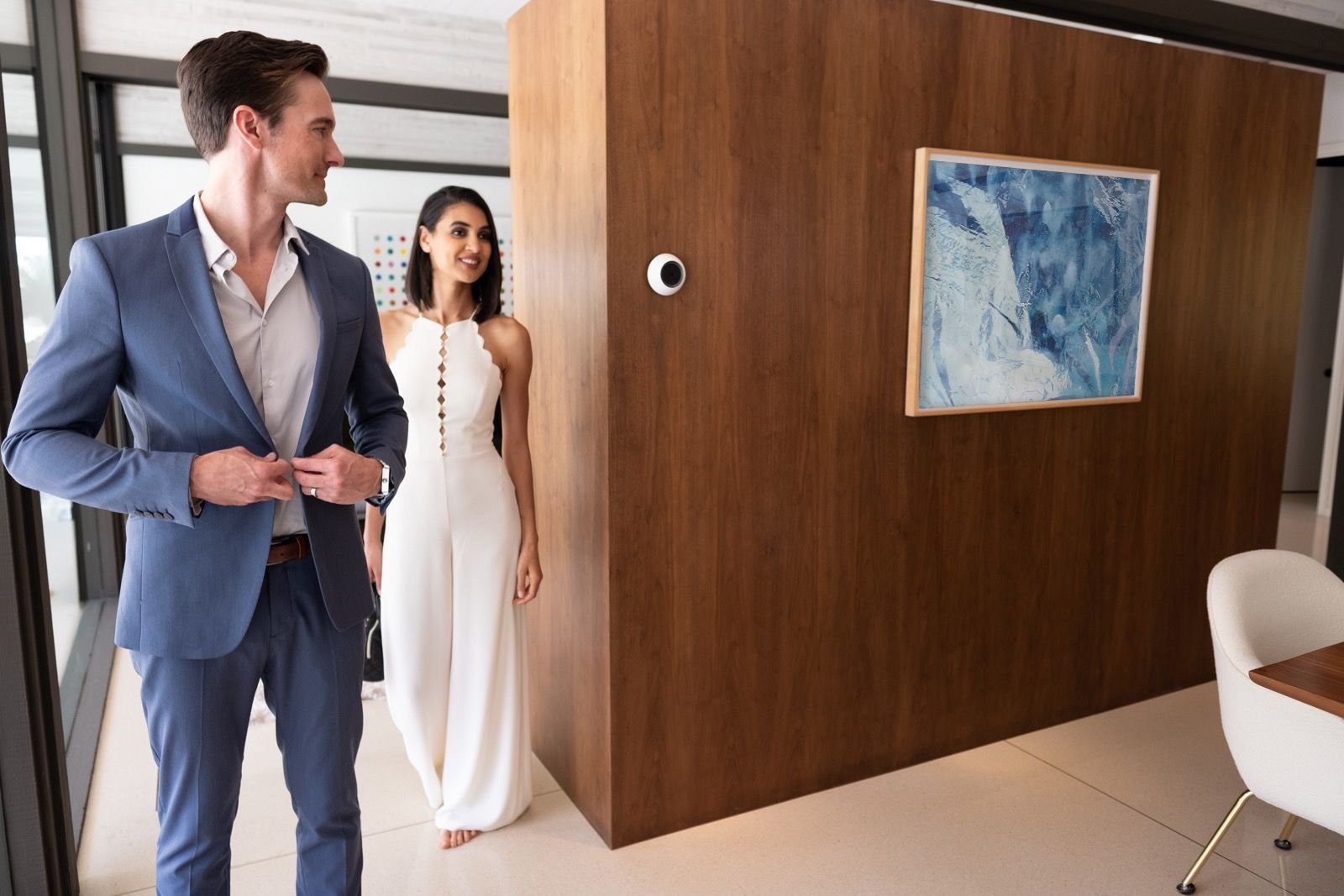 A couple walking through a refined modern home controlled by Josh.ai