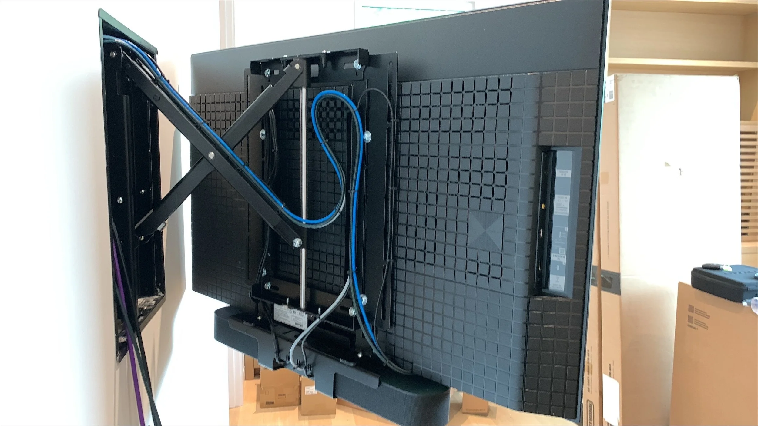 wall mounted tv in front of av equipment box