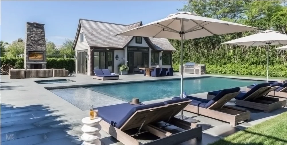 Hamptons backyard with pool, outdoor fireplace, and integrated outdoor entertainment