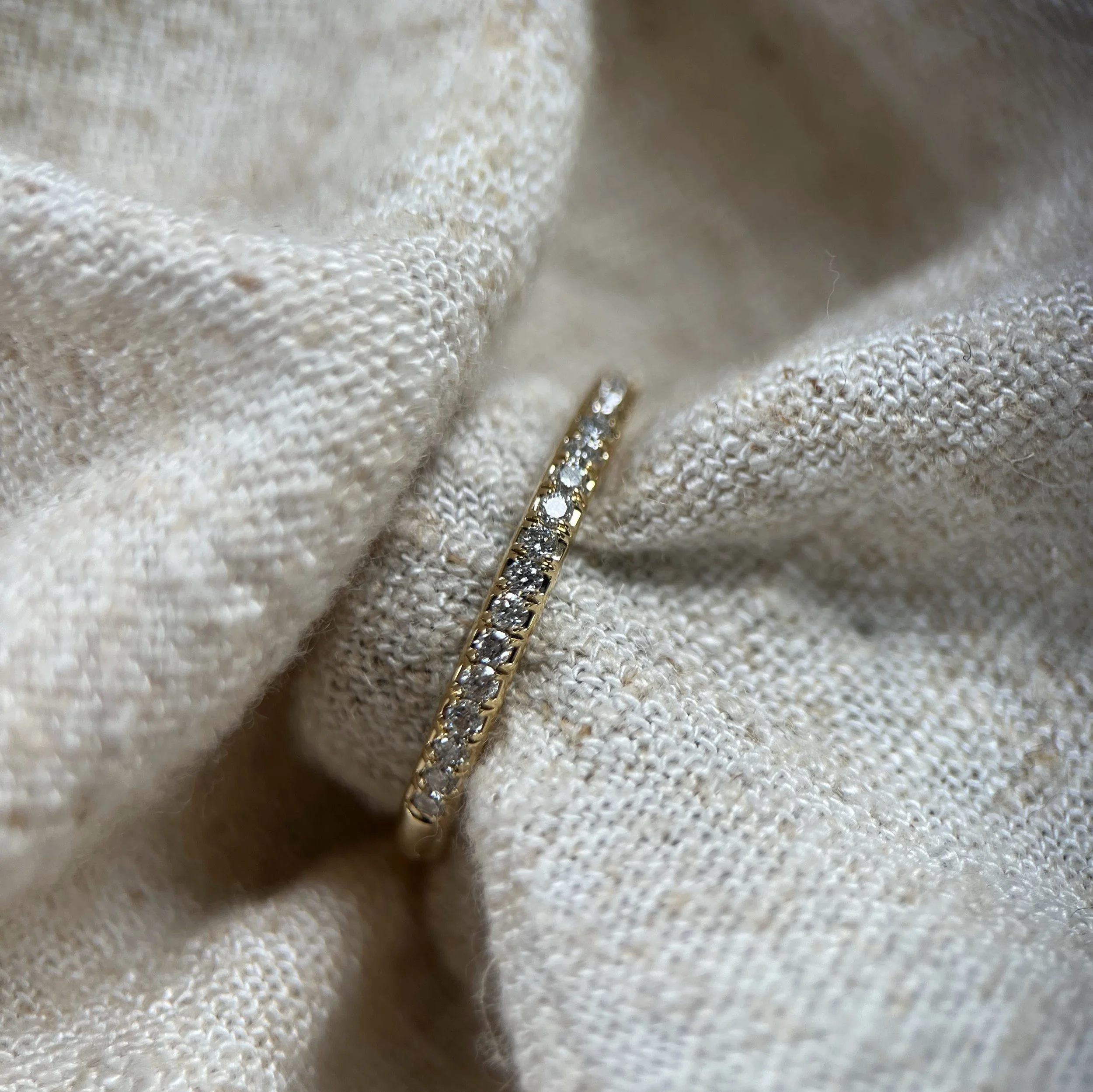 A delicate diamond set wedding / stacking ring in yellow gold