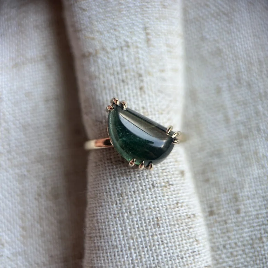 Moon shape deep green tourmaline set in yellow gold.