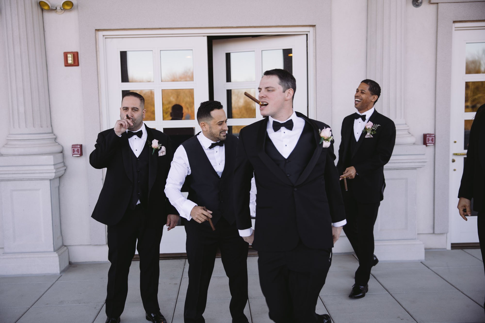 Groom and groomsmen smoking cigars 