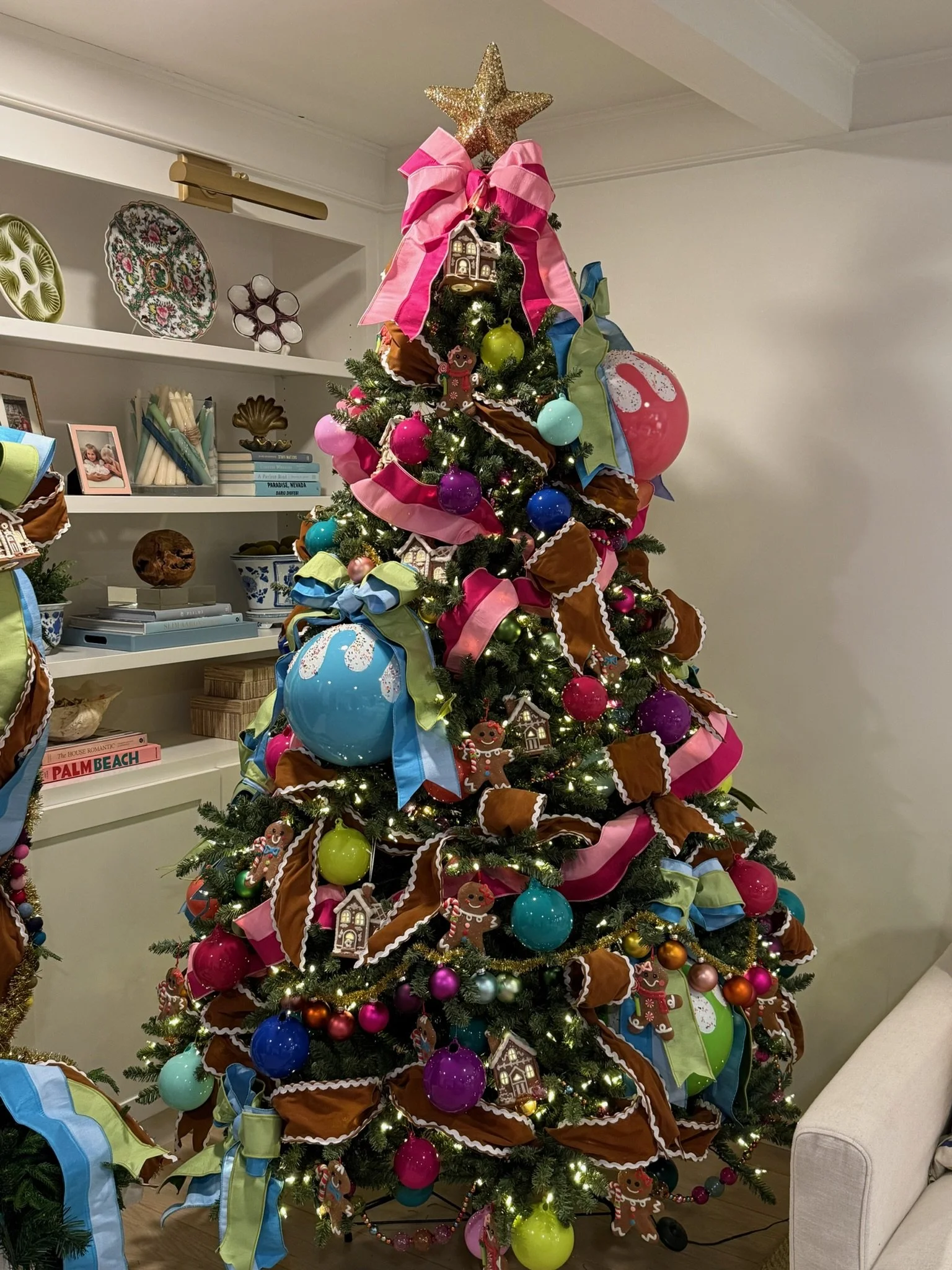 A colorful and bright decorated Christmas tree in a living room