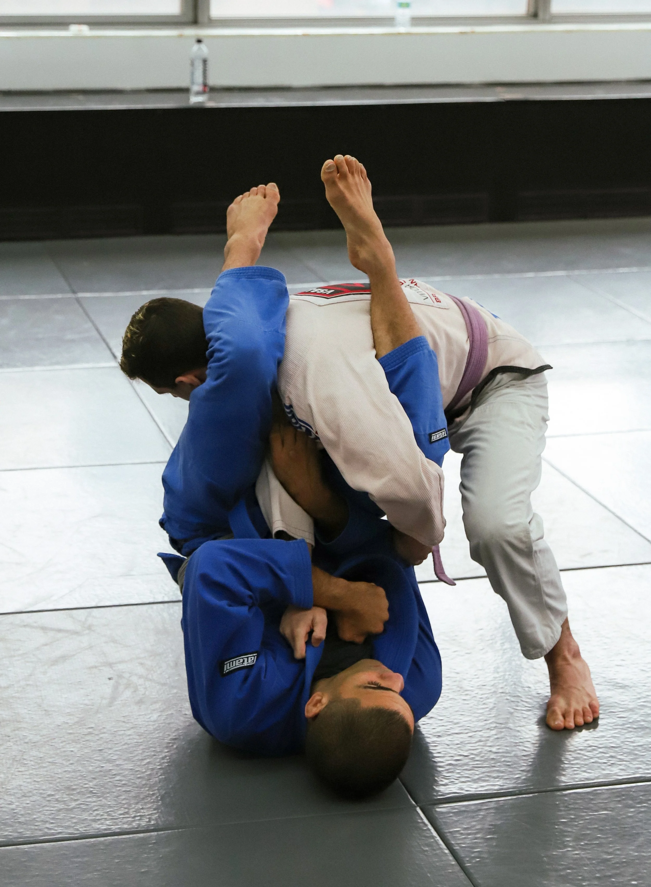 Two adult students practicing Jiu Jitsu holds