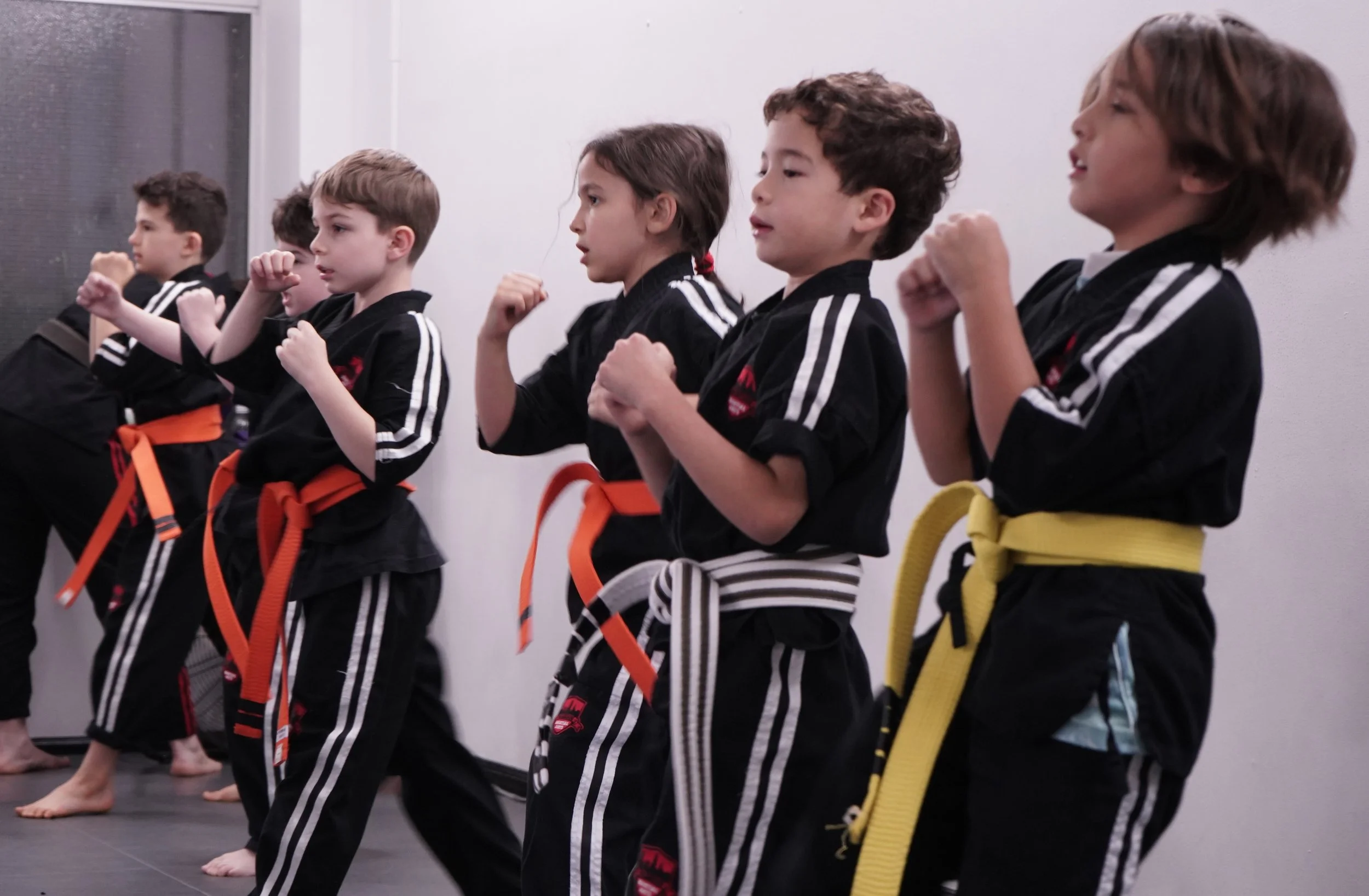 Children practicing karate fighting stance and punches in NYC kids martial arts class