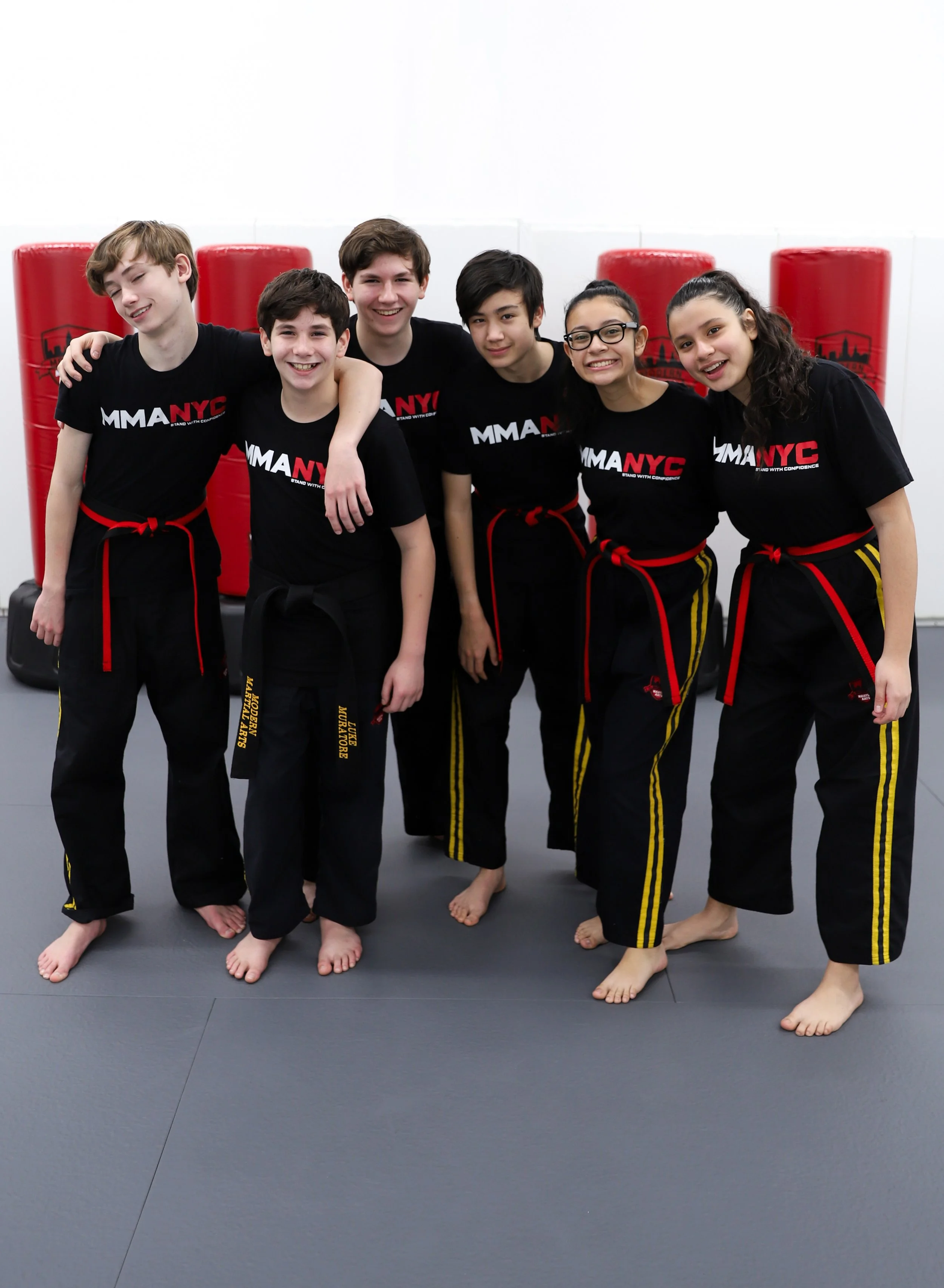 Teen martial artists hugging and smiling