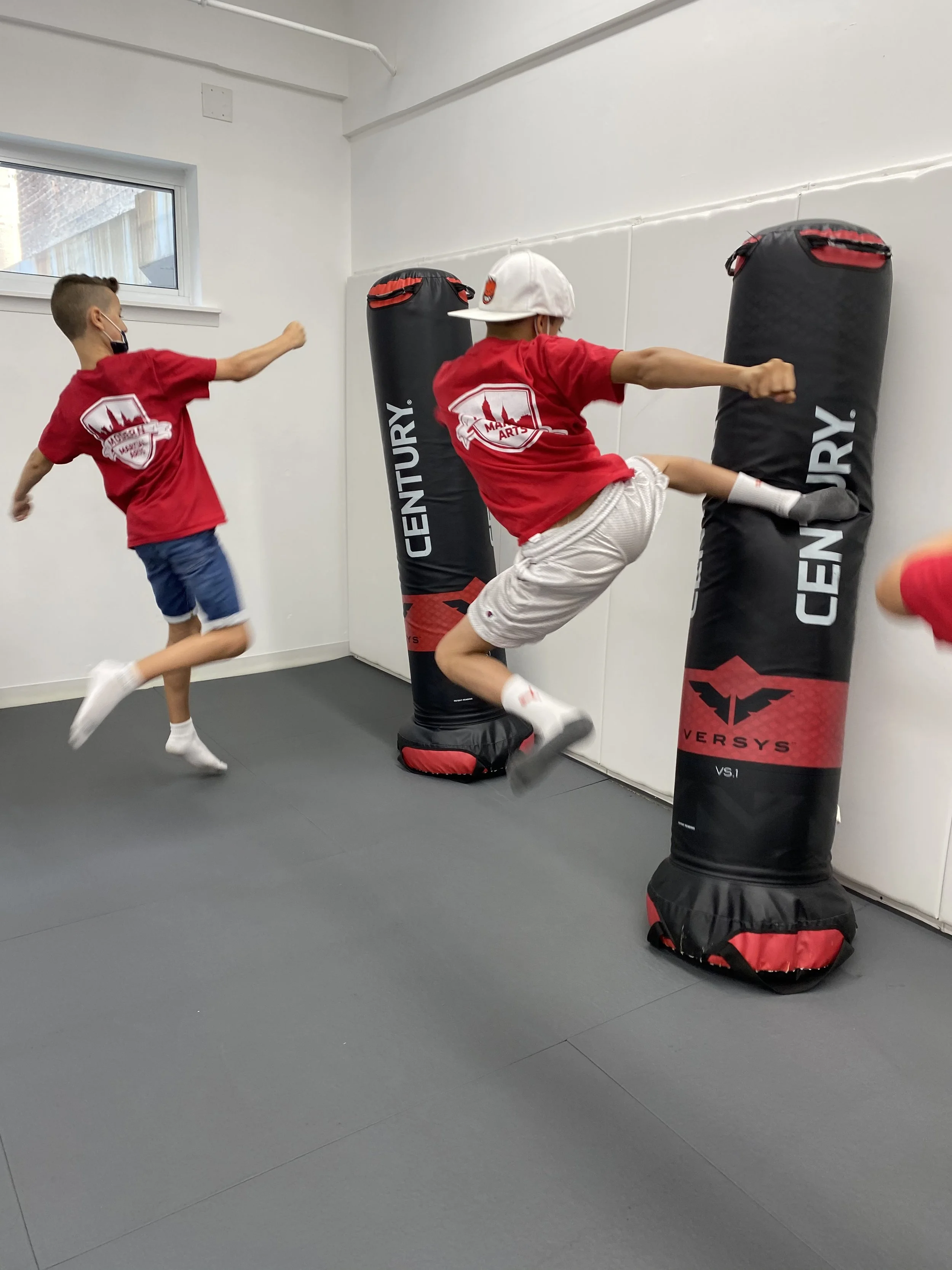 Summer Camp kids doing flying kicks in martial arts class