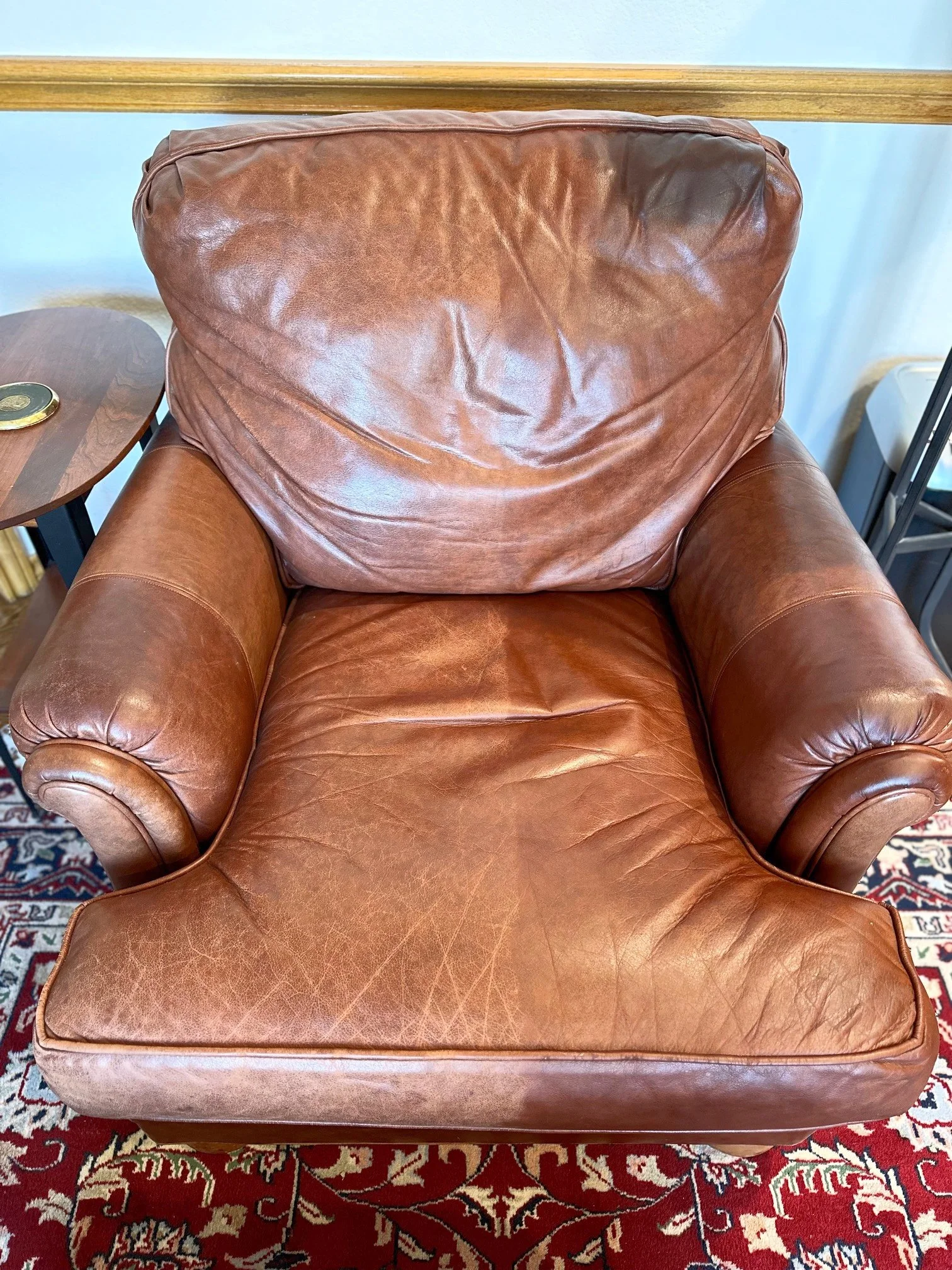 A leather arm chair, half untreated and the other half treated with Healthy Leather.