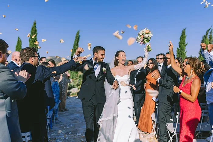 Bride and groom walking through wedding guests at Pyrgos Petreza
