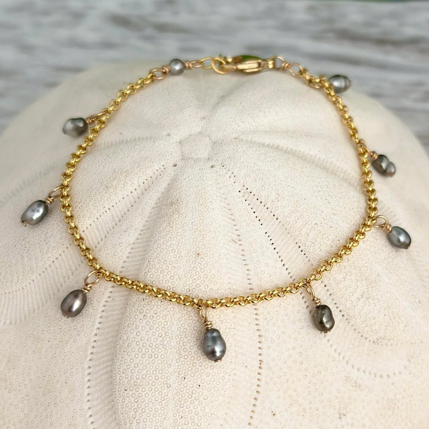 🌸NOW ONLINE 🌸
Delicate yet eye-catching, this Tahitian Keshi Pearl Charm Bracelet features luminous, free-form Keshi pearls dancing gracefully along your choice of a rich gold-filled or sleek sterling silver chain. Each rare pearl is composed entir
