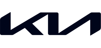 Close-up of the KIA logo on a vehicle, with dark background.