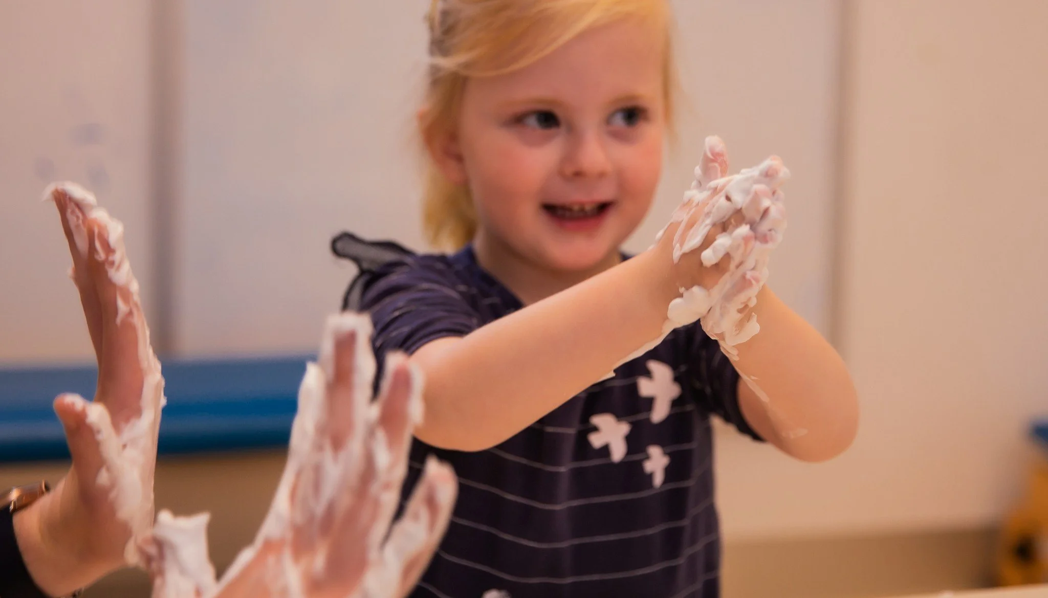 blonde girl smiles during OT session at kids plus geelong