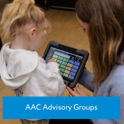 young blonde girl using aac device under guidance of a speech therapist