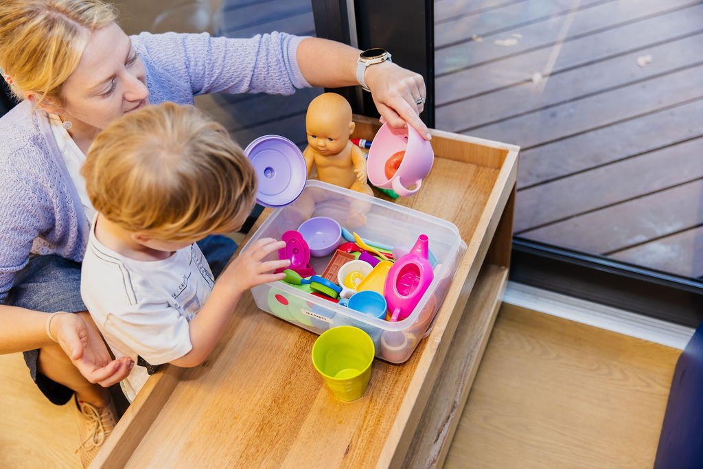 young blond child is guided through playtime by therapist