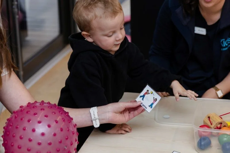 toddler boy plays with toys at low table