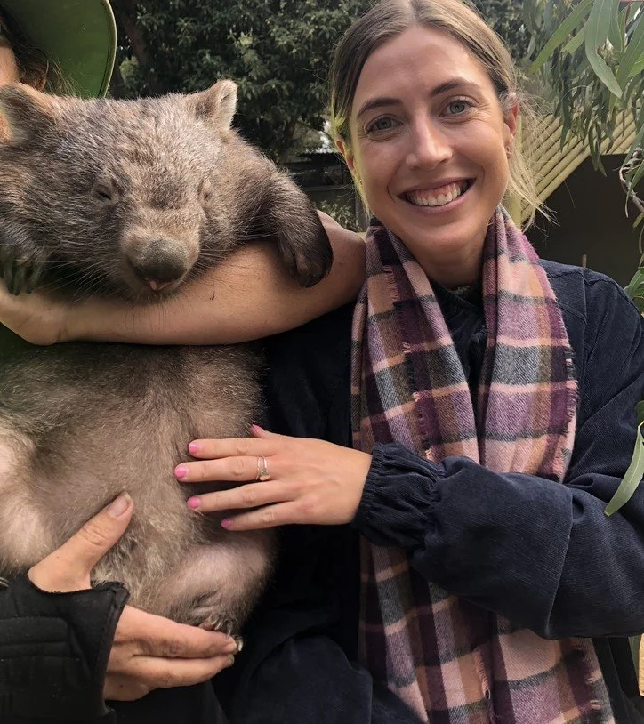 sharnie smiles for the camera with a wombat