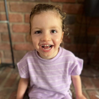 little girl with brown hair smiling