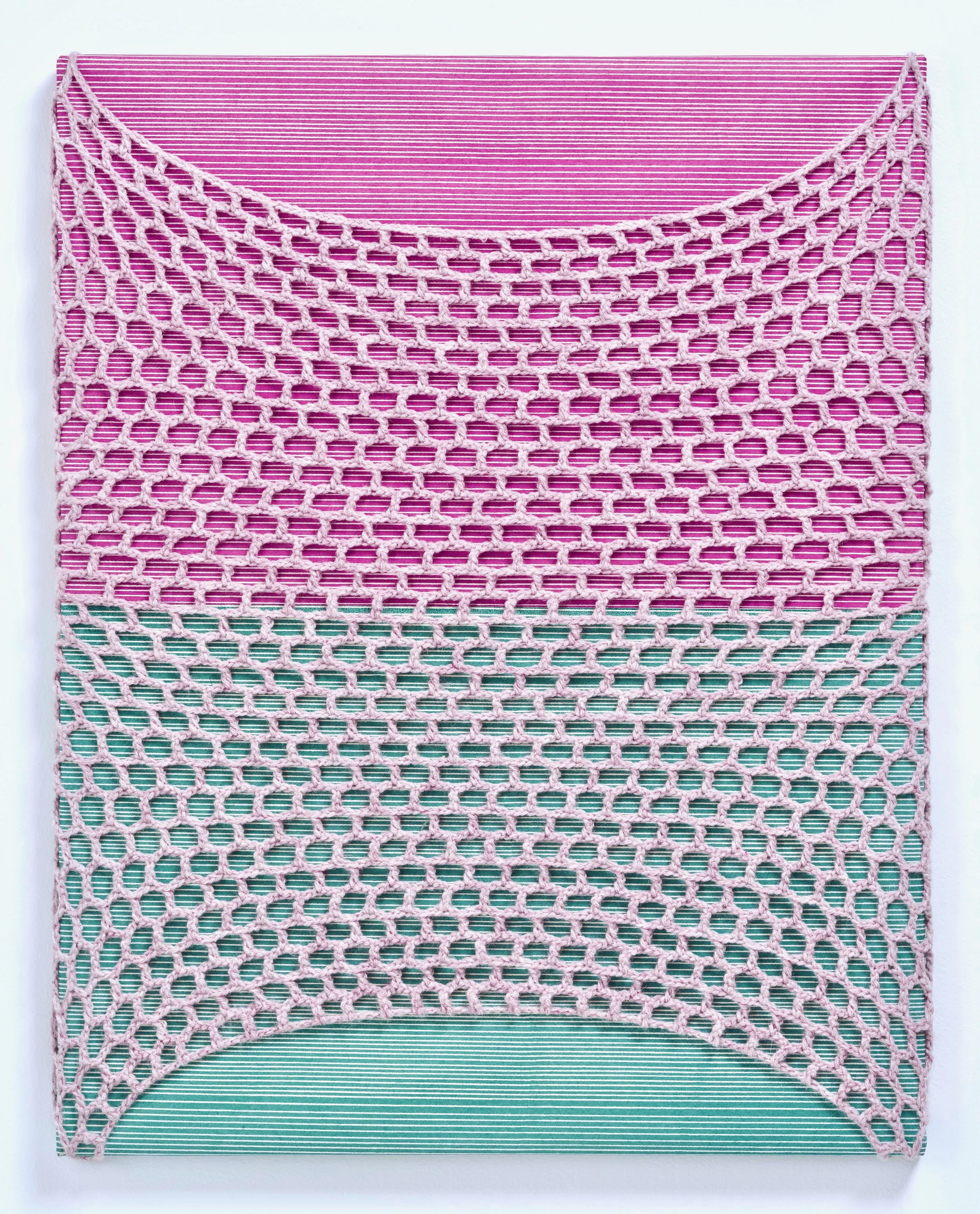 PInk yarn in honeycomb shapes netting around a green and pink canvas
