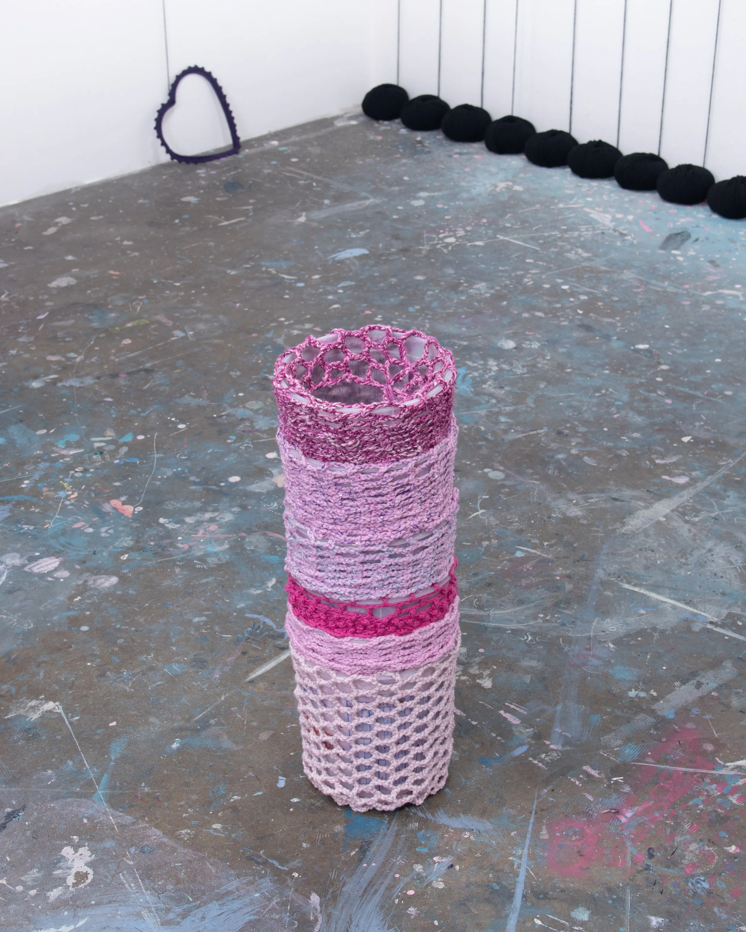 Buckets covered in different colors of pink yarn