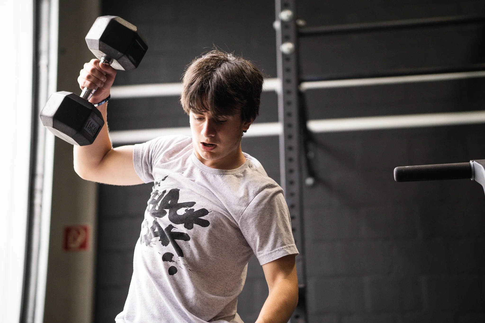 Atleet voert een snelle dumbbell workout uit tijdens een korte, intensieve Sweat 30 sessie bij Black Oak.