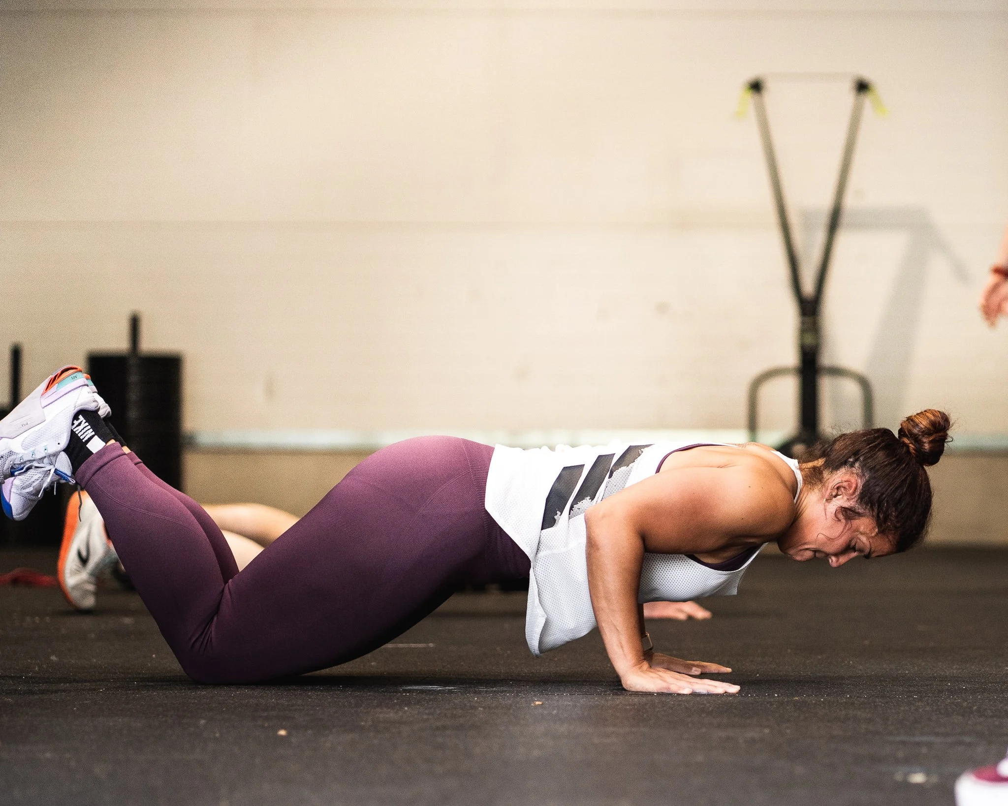 Gefocuste atlete voert een knielende push-up uit met perfecte vorm tijdens een Body Movement les bij Black Oak CrossFit Turnhout.