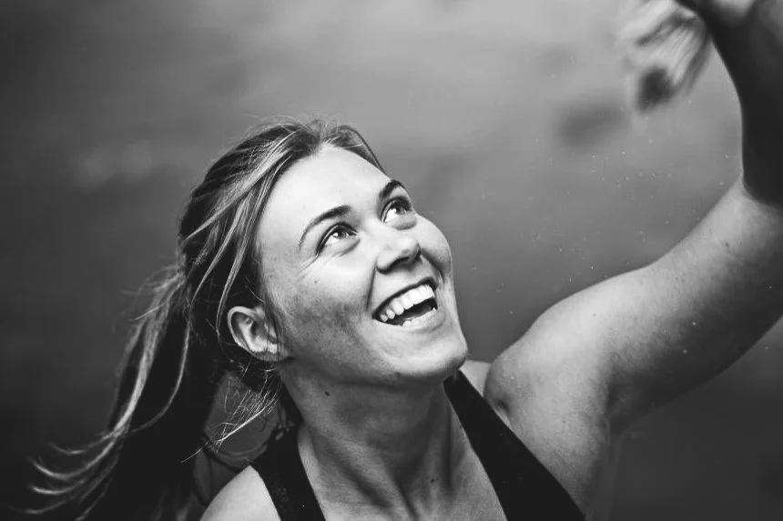 Lachende CrossFit coach Kim Volders van Black Oak Turnhout kijkt enthousiast omhoog tijdens een training.