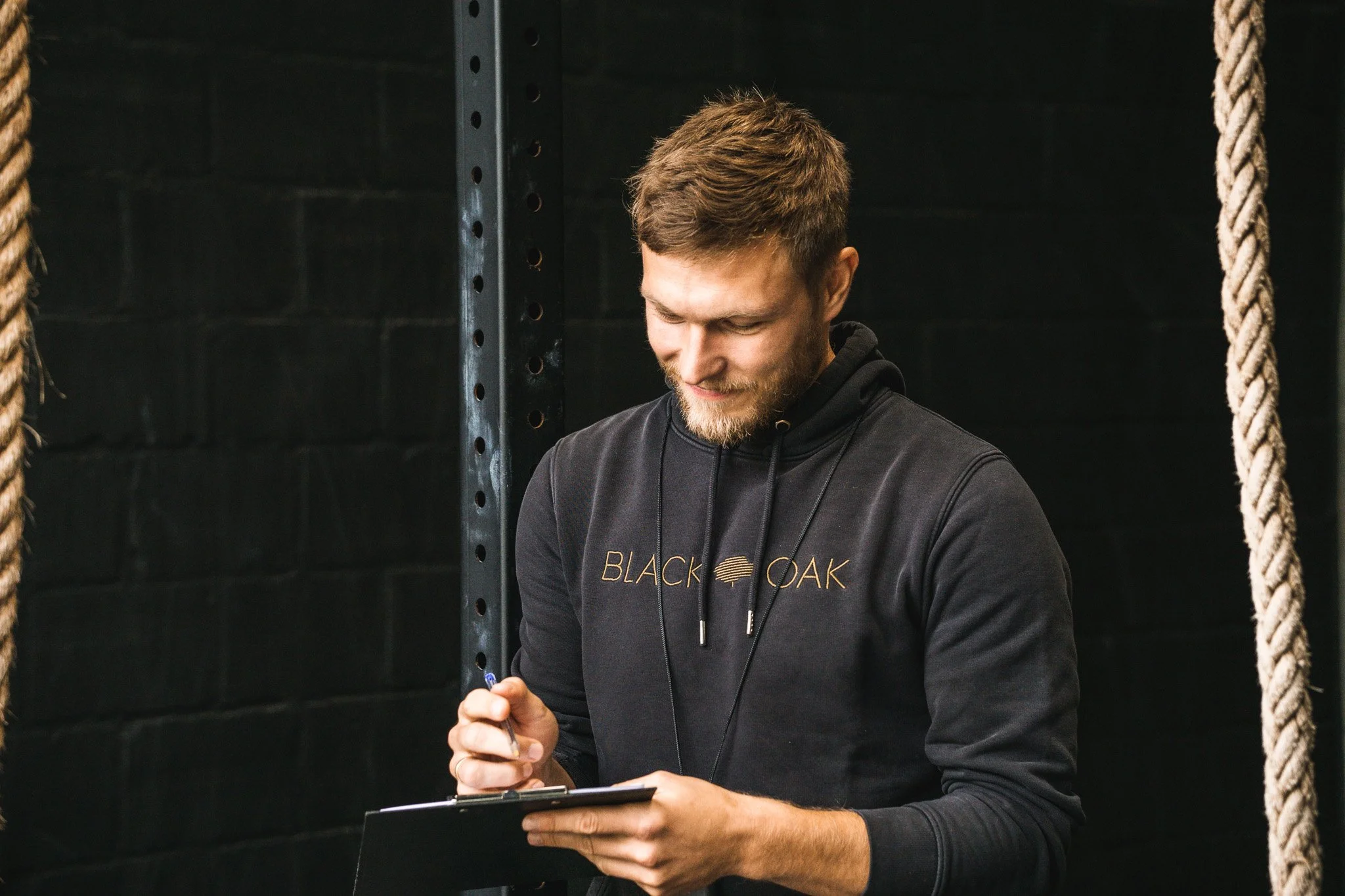 Brent Raeymaekers, co-eigenaar en coach bij Black Oak CrossFit Turnhout, maakt aantekeningen tijdens een training.