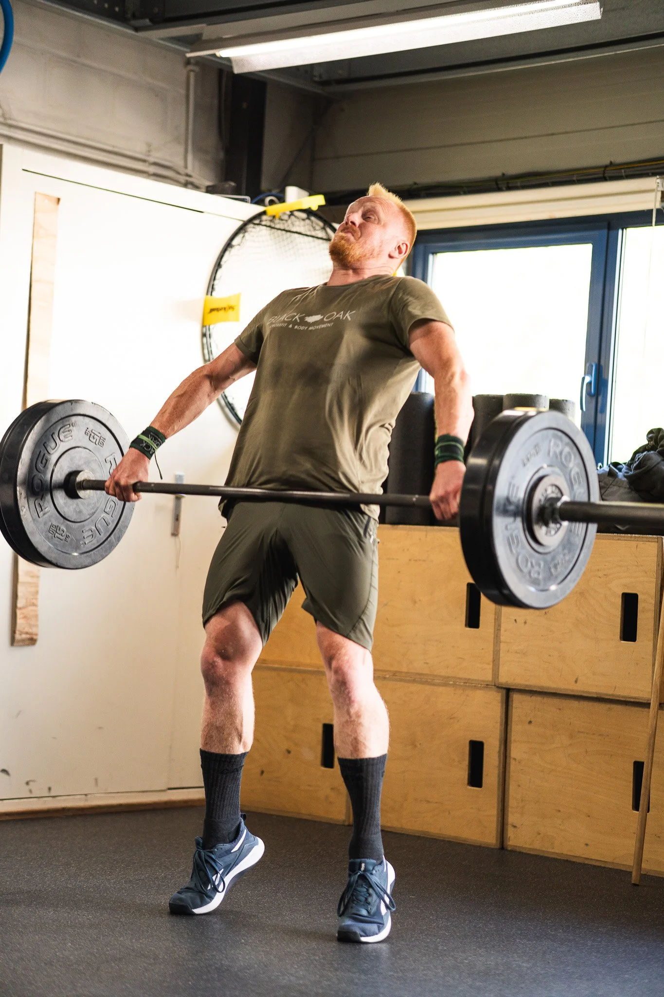 CrossFit atleet bij Black Oak Turnhout voert een explosieve extensie uit met een zware barbell tijdens een Oly Lifting sessie.
