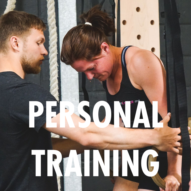 Een gecertificeerde coach van Black Oak Turnhout geeft persoonlijke begeleiding tijdens een personal training sessie aan de ringen.