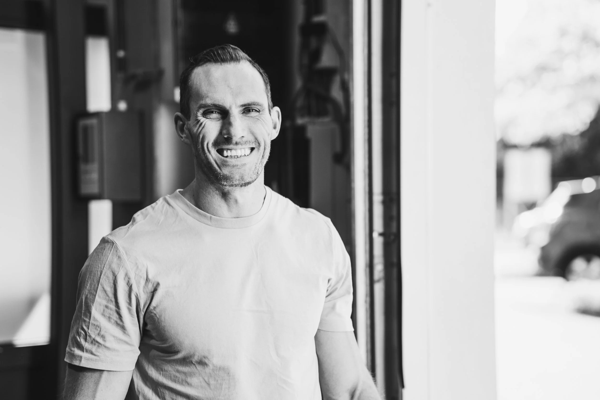 Lachende CrossFit coach van Black Oak Turnhout staat klaar voor persoonlijke begeleiding in de box.