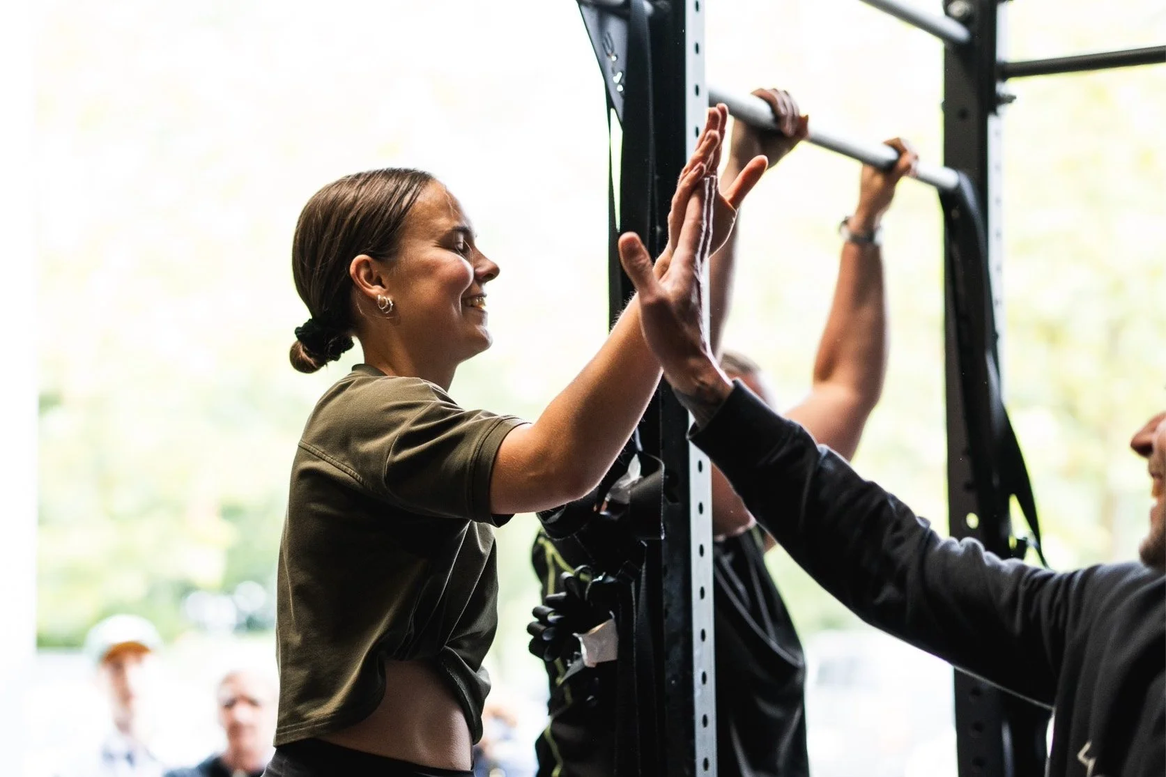 Lachende atlete krijgt een high-five van haar coach na een geslaagde personal training bij Black Oak CrossFit Turnhout.